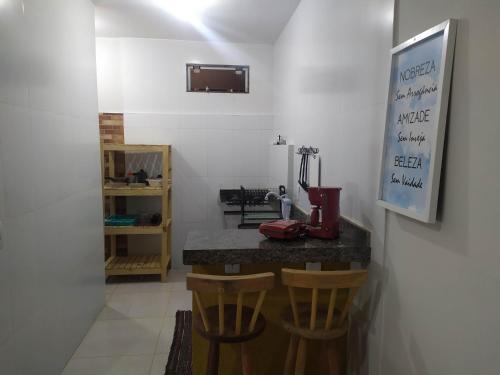 Armacao dos BuziosにあるStudio Mar & Solのキッチン(カウンター、木製のスツール2脚付)