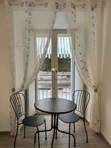 einen Tisch und Stühle in einem Zimmer mit Fenster in der Unterkunft NAPOLI VIBES Rooms in Neapel