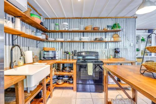 a kitchen with wooden shelves and a sink and a stove at Bohemian New Braunfels Home with River Access! in New Braunfels