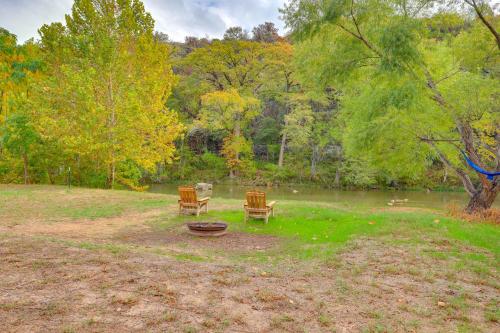 two chairs and a fire pit next to a pond at Bohemian New Braunfels Home with River Access! in New Braunfels