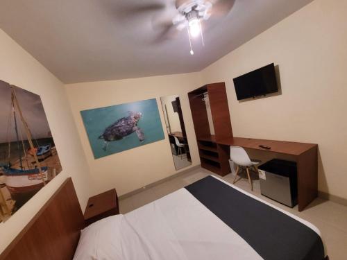 a bedroom with a bed and a desk and a television at Conde Hotel Piura in Piura