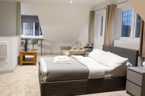 - une chambre avec un lit, un canapé et une chaise dans l'établissement KingsHouse In Cheam Village, à Cheam