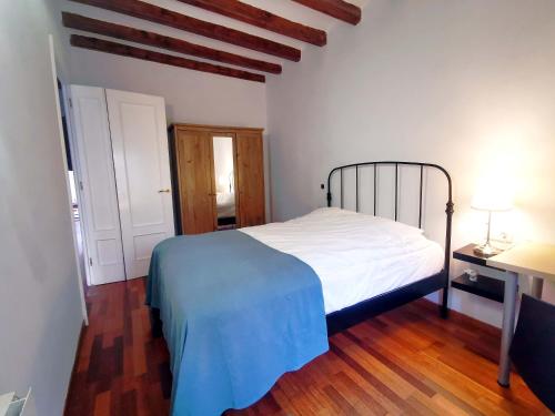 um quarto com uma cama branca e piso em madeira em VL51 em Barcelona