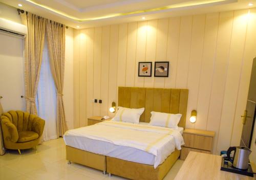 a bedroom with a large bed and a chair at Elcastillo Homes in Lagos