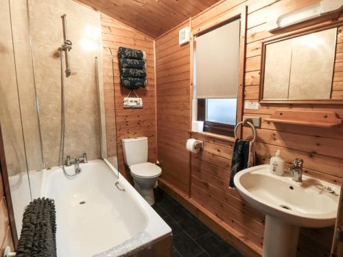 een badkamer met een bad, een wastafel en een toilet bij Sycamore Lodge in Saltburn-by-the-Sea