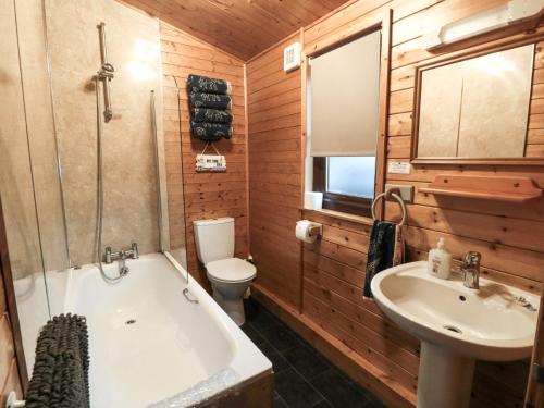 Un baño con bañera, lavabo e inodoro. en Sycamore Lodge, en Saltburn-by-the-Sea
