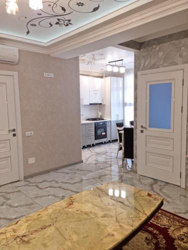 een woonkamer met een tafel en een keuken bij Modern Apartment in Chişinău