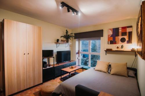 - une chambre avec un grand lit et une télévision dans l'établissement Alpine Home Sierra Nevada, à Sierra Nevada