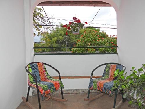 two chairs sitting on a porch looking out a window at La Molienda Casa Hotel in San Agustín