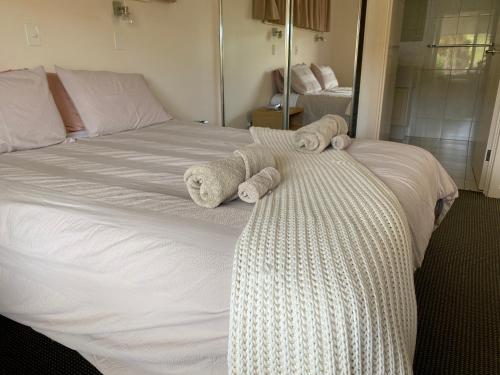 ein weißes Bett mit Handtüchern darüber in der Unterkunft Birubi Holiday Homes Kangaroo Island in Emu Bay