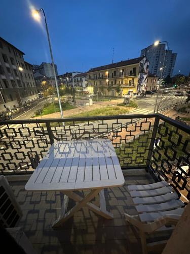a white bench sitting on top of a balcony at Gigli, rooms con cucina in comune e terrazza in Milan