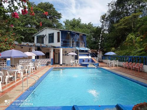 Finca Villa Luz في Nimaima: مسبح بالطاولات والكراسي امام المنزل