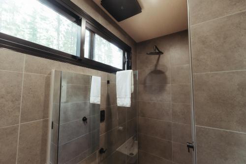 uma casa de banho com um chuveiro e uma cabina de duche em vidro. em CABN Kuitpo Forest em Kuitpo