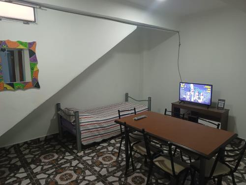 a room with a table and a bed and a tv at Mi cielo in Santa María
