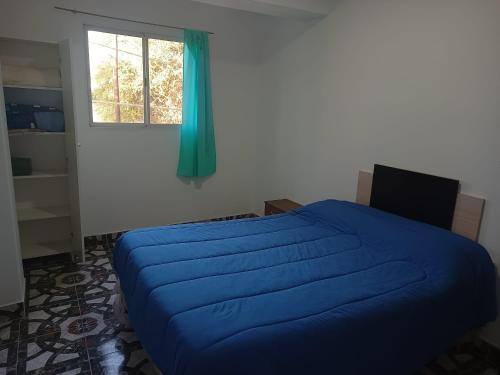 a bedroom with a blue bed and a window at Mi cielo in Santa María