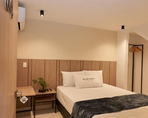 a bedroom with a bed and a table with a pillow at Elemont Hotel in Medellín