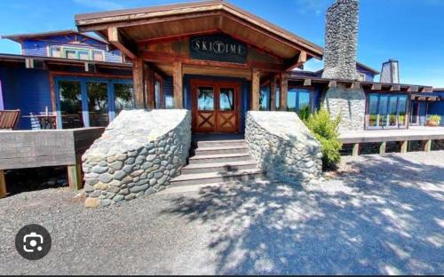 a building with a wooden door and a stone wall at Methven Retreat in Methven