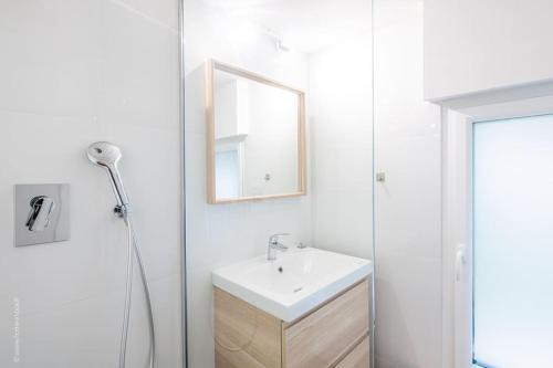 a white bathroom with a sink and a mirror at L'Atelier Loft-Invalides Tour Eiffel- 6 pers-2 Chambres - Cosy in Paris