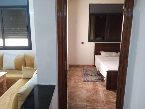 a small room with a bed and a couch at Appartement familial 1 in Oualidia