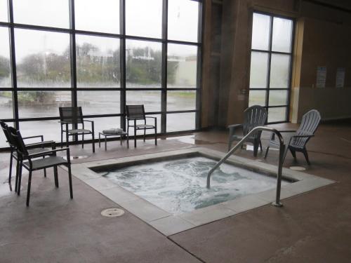 a hot tub in a room with chairs and a table at Pacific Sunrise Inn & Suites in Ocean Shores