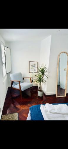 Habitación con 2 camas, espejo y silla. en El sauce de la calle Sinagoga Precioso apartamento en el centro de La Coruña, en A Coruña