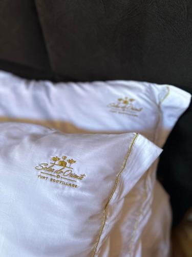 a white pillow with logos on it on a bed at Glamping montain experience in São Joaquim