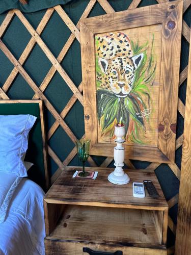 a bedroom with a painting of a leopard on the wall at Glamping montain experience in São Joaquim