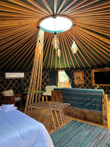 a room with a bed and a couch in a yurt at Glamping montain experience in São Joaquim