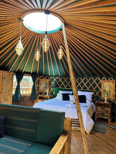 a bedroom in a yurt with a bed and a couch at Glamping montain experience in São Joaquim
