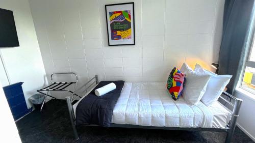 a bed in a room with a table and a chair at Urban Lounge Sleepery in Rotorua