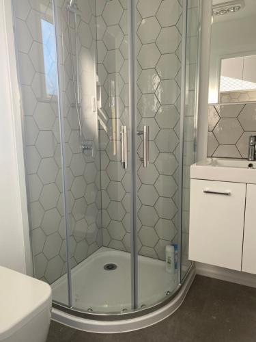 a shower with a glass door in a bathroom at Methven Retreat Tiny House in Methven