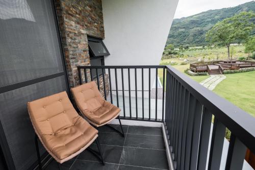 two chairs sitting on a balcony with a view at The Silence Manor in Ruisui