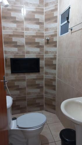 a bathroom with a toilet and a sink at Pousada Lagoinha in Ubatuba