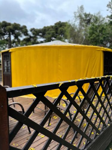 a yellow tent with a bike on a bridge at Glamping montain experience in São Joaquim