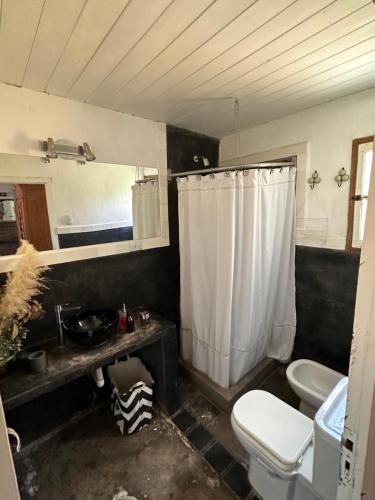 uma casa de banho com um WC, um lavatório e um chuveiro em Casa divina temporaria en Tafí Del Valle ,pleno centro em Tafí del Valle