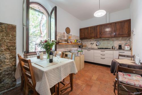 a kitchen with a table with a vase of flowers on it at Antico Podere Il Bugnolo in Poggibonsi