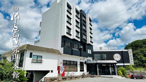 a large white building with a sign on it at Global Resort Misen - グローバルリゾート弥山 in Hatsukaichi