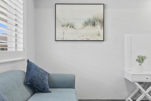 a living room with a chair and a picture on the wall at Shellharbour Village Motel in Shellharbour