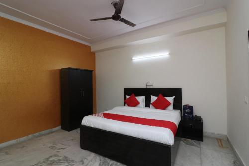 um quarto com uma cama grande e almofadas vermelhas em Collection O Delta Square em Gurgaon