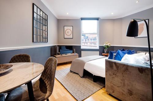 ロンドンにあるARCORE Premium Rental Shaftesbury Avenueのベッドルーム1室(ベッド1台、テーブル付)、ダイニングルームが備わります。