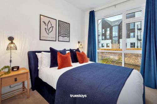 sypialnia z łóżkiem z niebieskimi zasłonami i oknem w obiekcie NEW Canalside House / 3 Bedroom House in Stoke-on-Trent w mieście Stoke-on-Trent