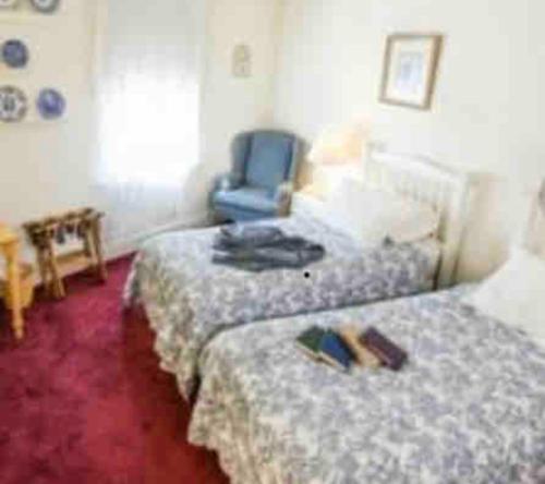 a hotel room with two beds and a blue chair at The Currier Inn in Greeley