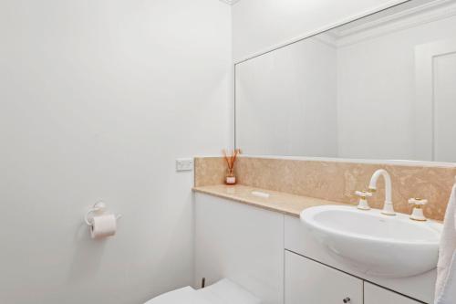 a white bathroom with a sink and a mirror at Peninsula Waters Unit 14 Soldiers Point Road 2 in Soldiers Point