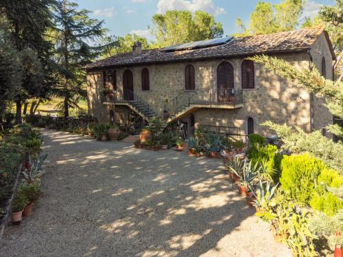 an old stone house with a staircase and plants at Antico Podere Il Bugnolo in Poggibonsi