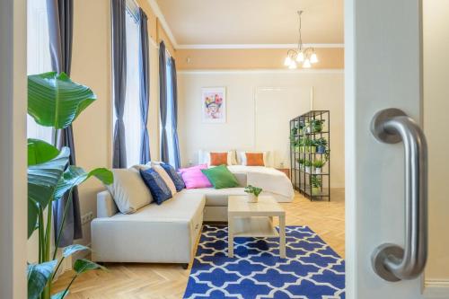 sala de estar con sofá blanco y alfombra azul en Best Seasons La Famiglia, en Budapest