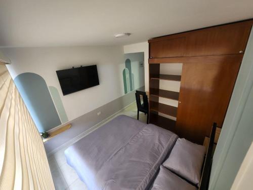 una piccola camera con letto e TV a schermo piatto di Habitación 10 min Aeropuerto C a Bogotá