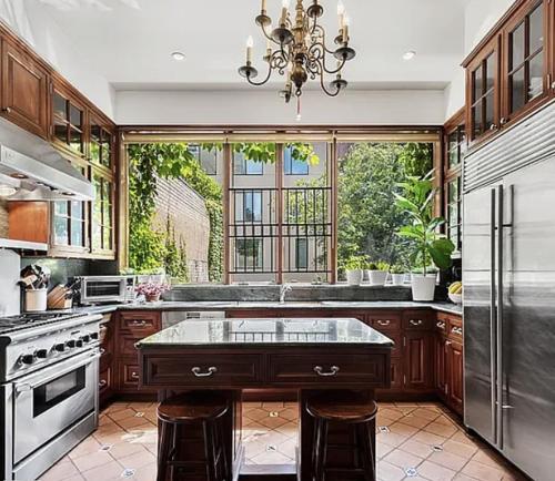 a large kitchen with a large window and a kitchen island at E 60s Townhouse comfortable, quiet, easy to manage 3 bedrooms w gym that can also be a 4th bedroom in New York