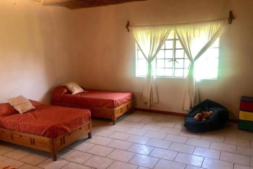 Zimmer mit 2 Betten und einem Fenster in der Unterkunft Casa de campo cerca de Guadalajara. in San Isidro Mazatepec