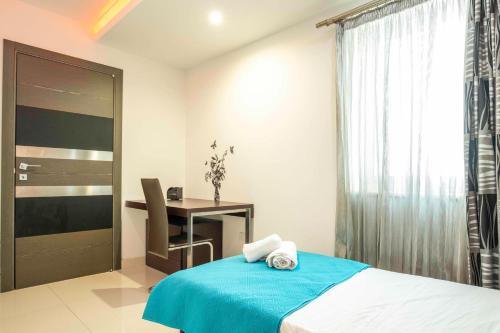a bedroom with a bed and a desk and a window at Oceanfront 3BR Penthouse Luxury & Views in Sliema in Sliema