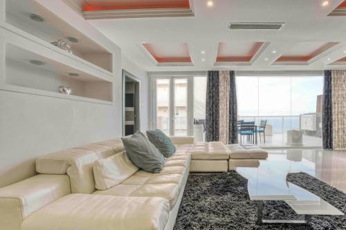 a living room with a white couch and a glass table at Oceanfront 3BR Penthouse Luxury & Views in Sliema in Sliema